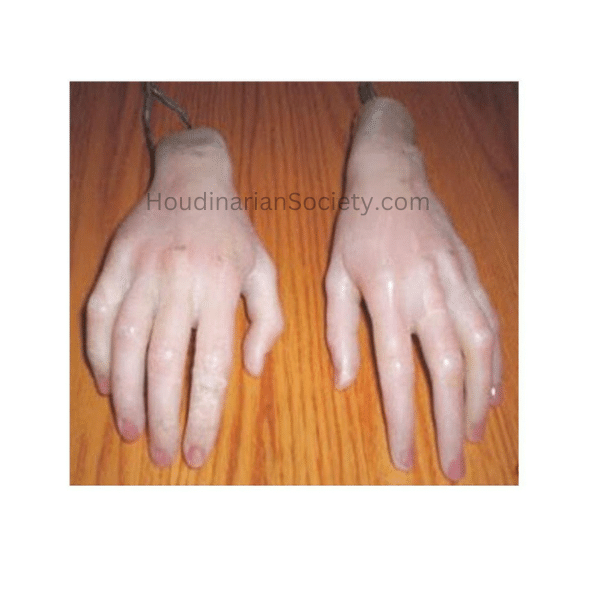 Two realistic mannequin hands on a wood-textured surface with wires attached to the wrists.