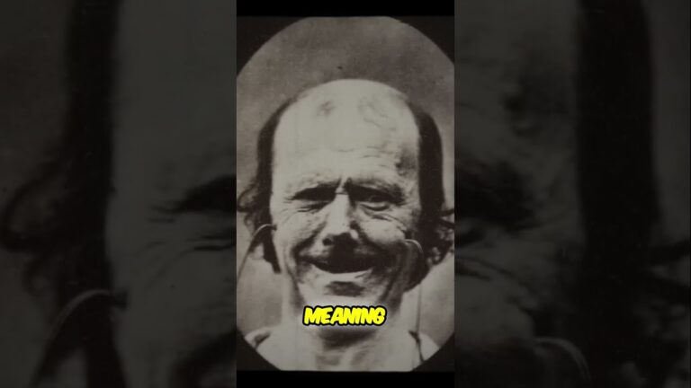 A black and white photo of a man with a pronounced smile and thinning hair. The word "MEANING" is overlaid at the bottom center.